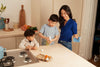 Blueland co-founder Sarah with her two young children cleaning their kitchen counter with multi-surface cleaner