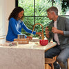 Man and woman in a kitchen with a modern faucet and countertop.