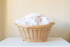 A basket filled with freshly laundered white clothes