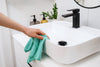 Cleaning a bathroom sink with a reusable cloth for a low-waste routine