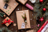 Holiday gifts wrapped in brown paper with ribbons and evergreen sprigs