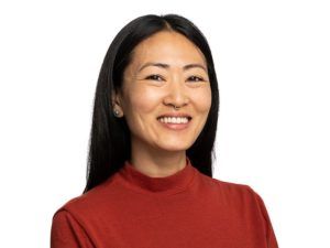 Woman wearing a red turtleneck against a white background