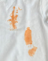 A white shirt stained with orange sauce