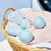 Wool dryer balls in a laundry basket with towels and sheets
